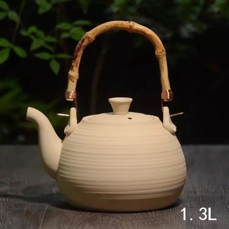 braune Teekanne aus Keramik mit Bambusgriff